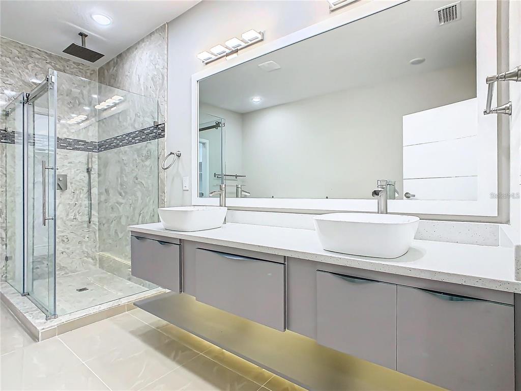 2000 Greenbriar Terrace Davenport, FL 33837 - Photo 39 of 50 a bathroom with a sink a large mirror and shower