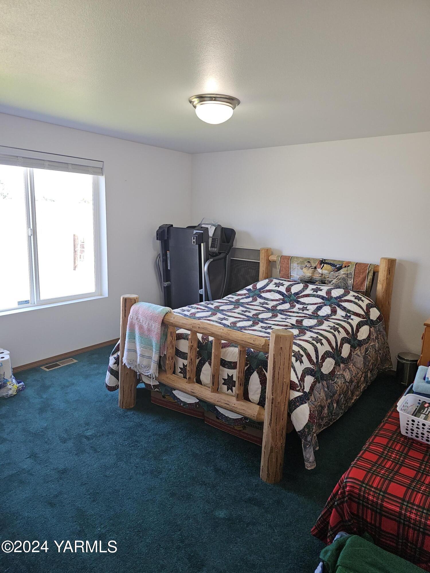 12933 Missimer Road Prosser, WA 99350 - Photo 8 of 39 a bedroom with a bed next to a window