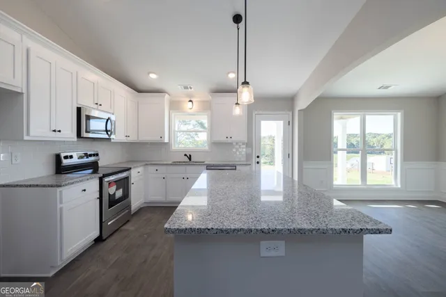 a view of a kitchen island a chandelier and wooden floor