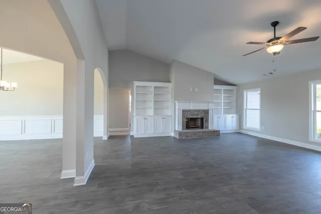 an empty room with windows and fireplace