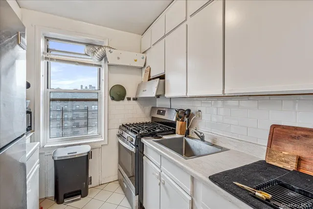 a kitchen with granite countertop a sink stove and refrigerator