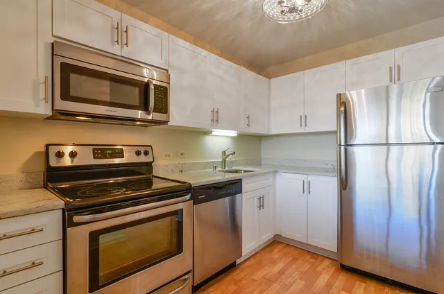 a kitchen with stainless steel appliances granite countertop a stove microwave and refrigerator