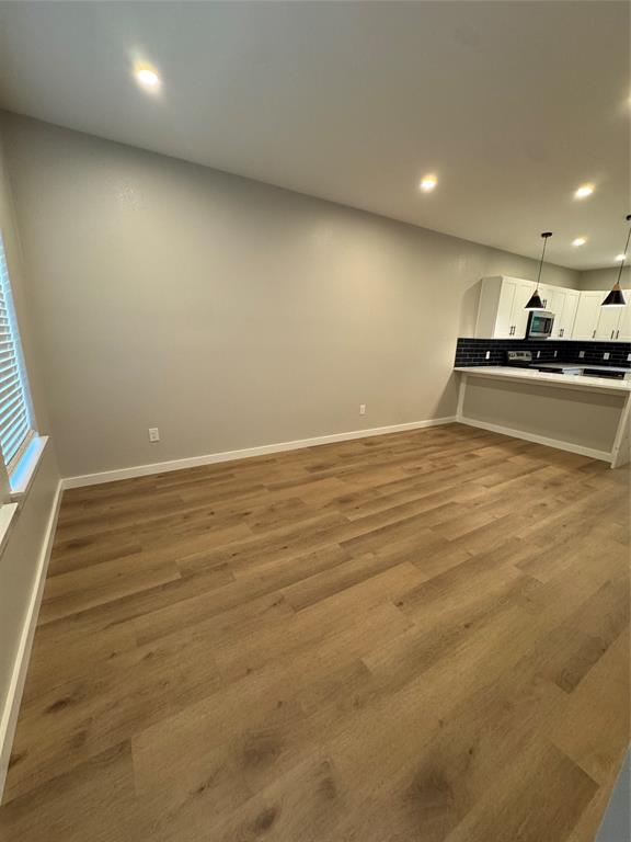 1505 Park Street, Unit A Commerce, TX 75428 - Photo 5 of 25 an empty room with wooden floor and windows