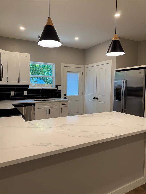 1505 Park Street, Unit A Commerce, TX 75428 - Photo 8 of 25 a kitchen with stainless steel appliances a stove a refrigerator a sink and a large window