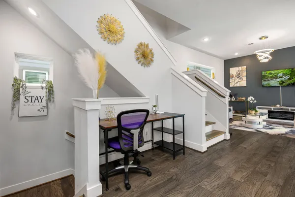 a view of a hallway with workspace and wooden floor