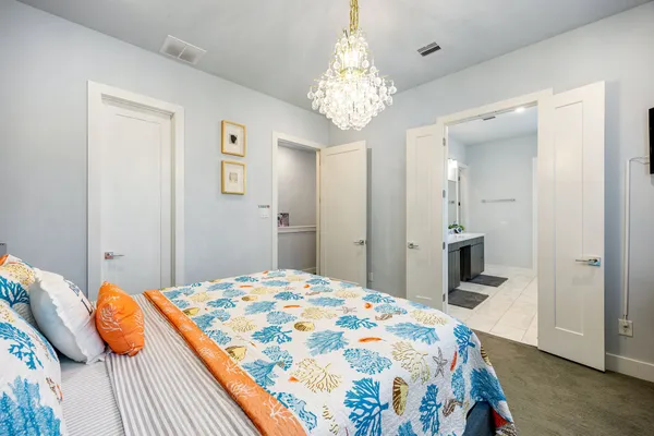 a bedroom with a bed and a chandelier