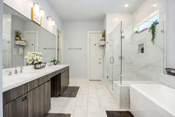 a spacious bathroom with a tub sink shower and mirror