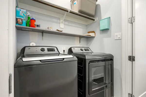 a utility room with dryer washer and empty racks