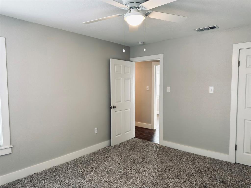 1908 South 19th Street Waco, TX 76706 - Photo 12 of 18 an empty room with a ceiling fan and carpet
