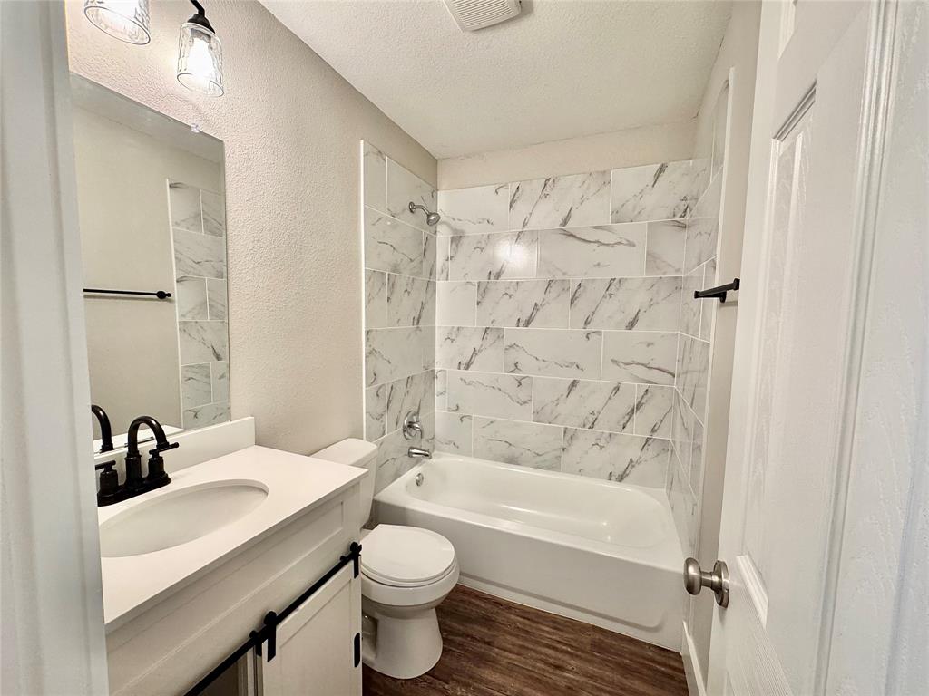 1908 South 19th Street Waco, TX 76706 - Photo 16 of 18 a bathroom with a sink toilet a shower and a bathtub