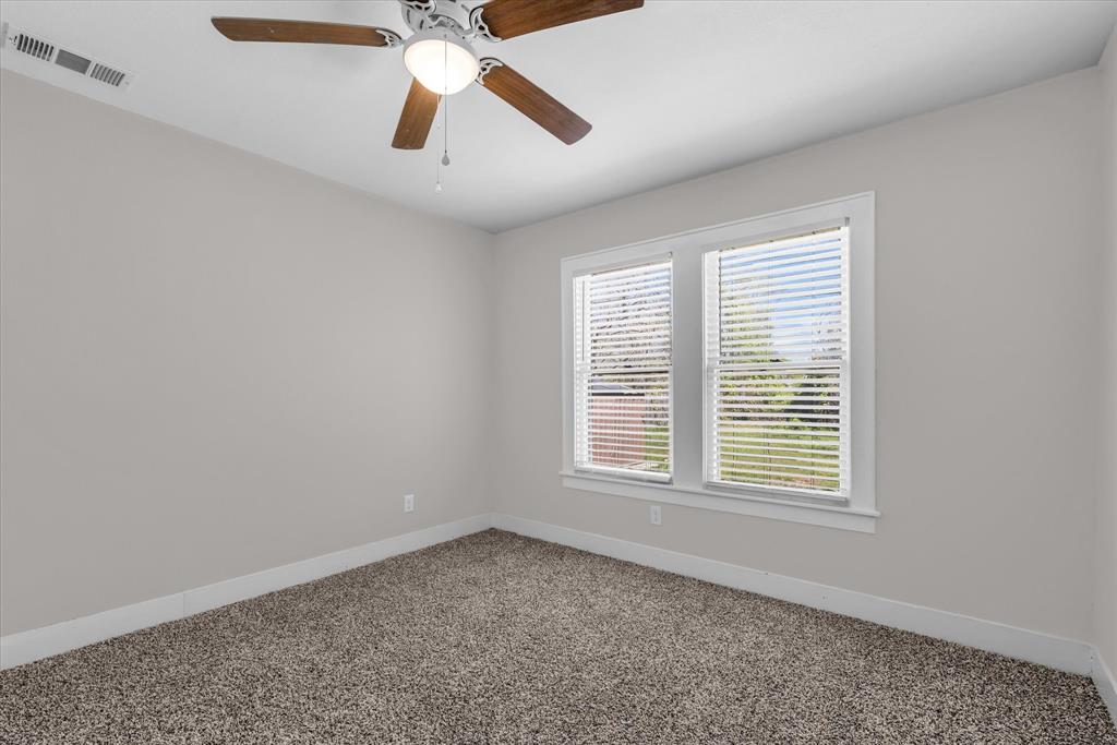 1908 South 19th Street Waco, TX 76706 - Photo 19 of 29 an empty room with chandelier fan and windows