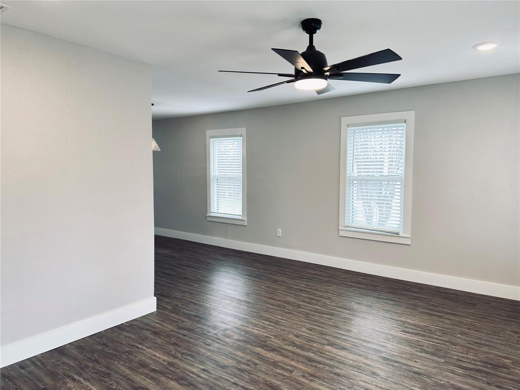 1908 South 19th Street Waco, TX 76706 - Photo 6 of 18 a view of a livingroom with a hardwood floor a ceiling fan and windows