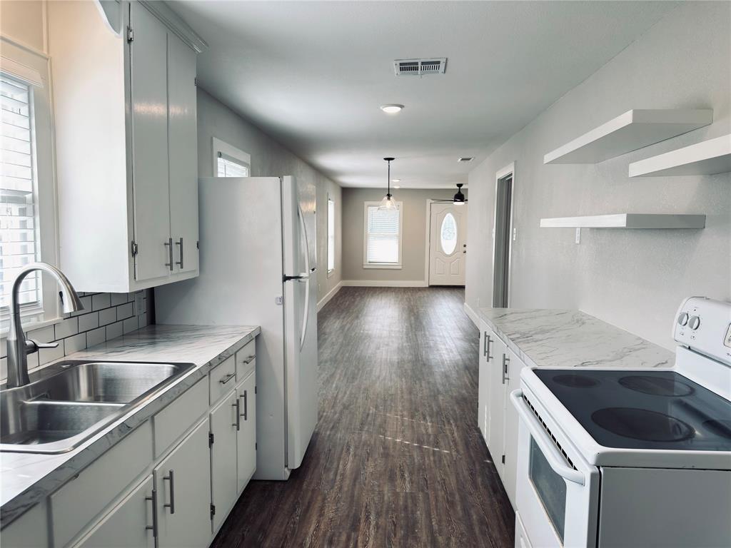 1908 South 19th Street Waco, TX 76706 - Photo 10 of 18 a kitchen that has a sink a stove and cabinets