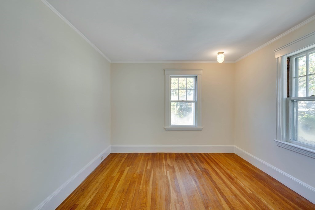 31 Ronald Road Arlington, MA 02474 - Photo 20 of 29 an empty room with wooden floor and windows