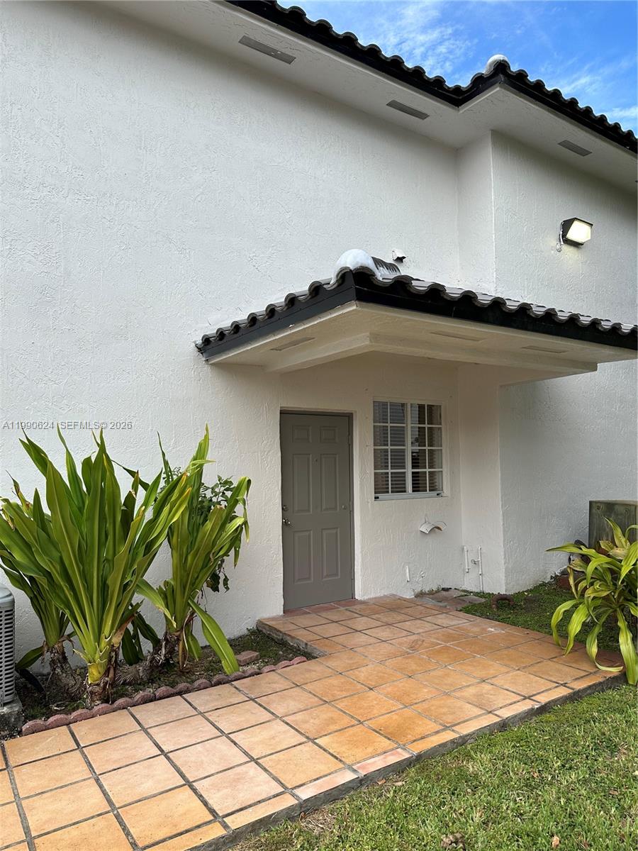 7549 Northwest 175th Street, Unit 7549 Hialeah, FL 33015 - Photo 4 of 34 a house with a yard and table and potted plants