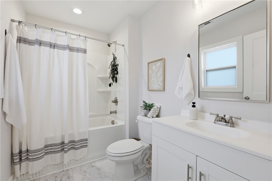 1 Brock Street Pelzer, SC 29669 - Photo 20 of 25 A well-appointed bathroom offers a crisp, clean aesthetic with pristine white fixtures and marble-look flooring.