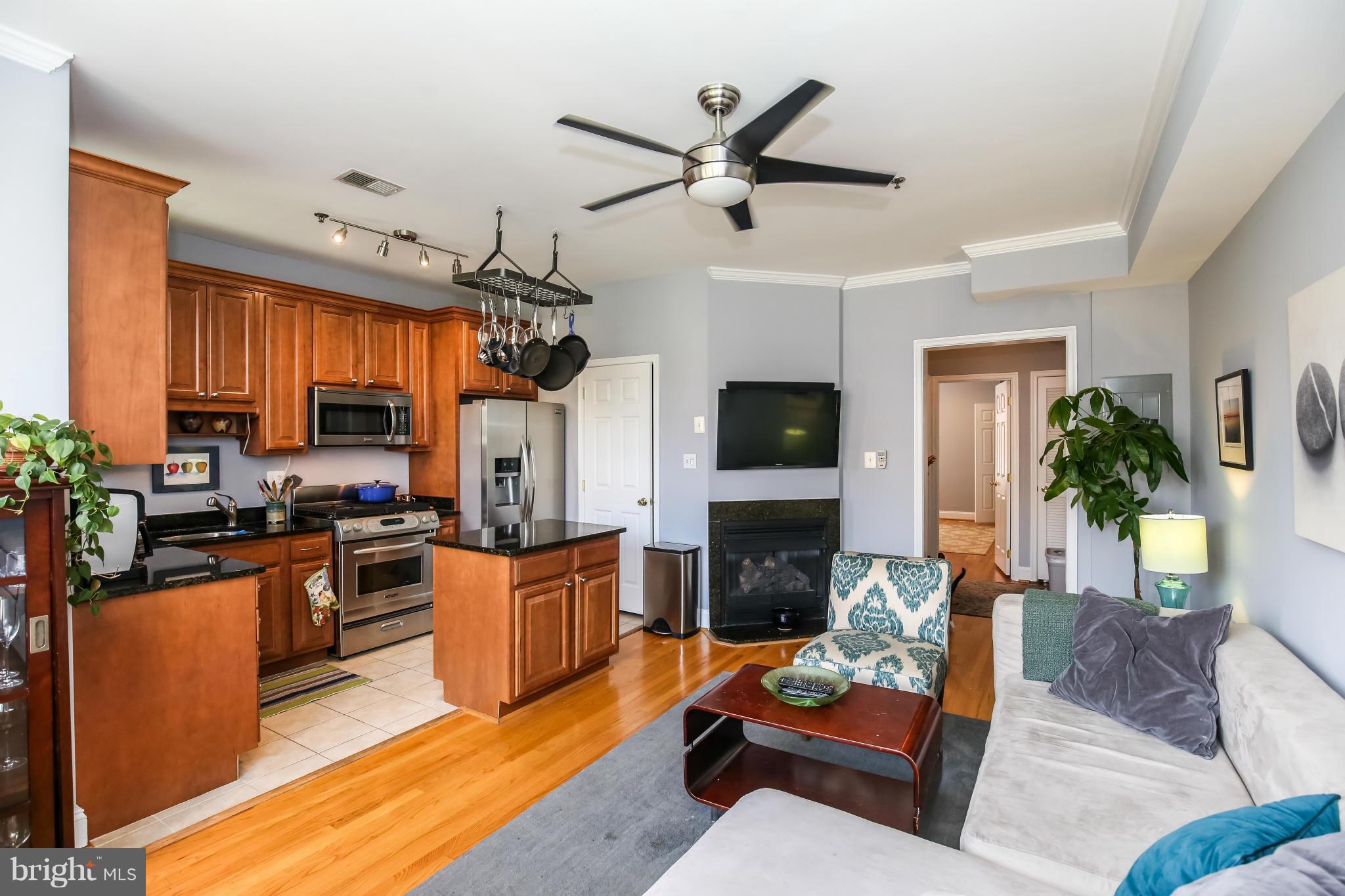 a living room with furniture kitchen view and a fireplace