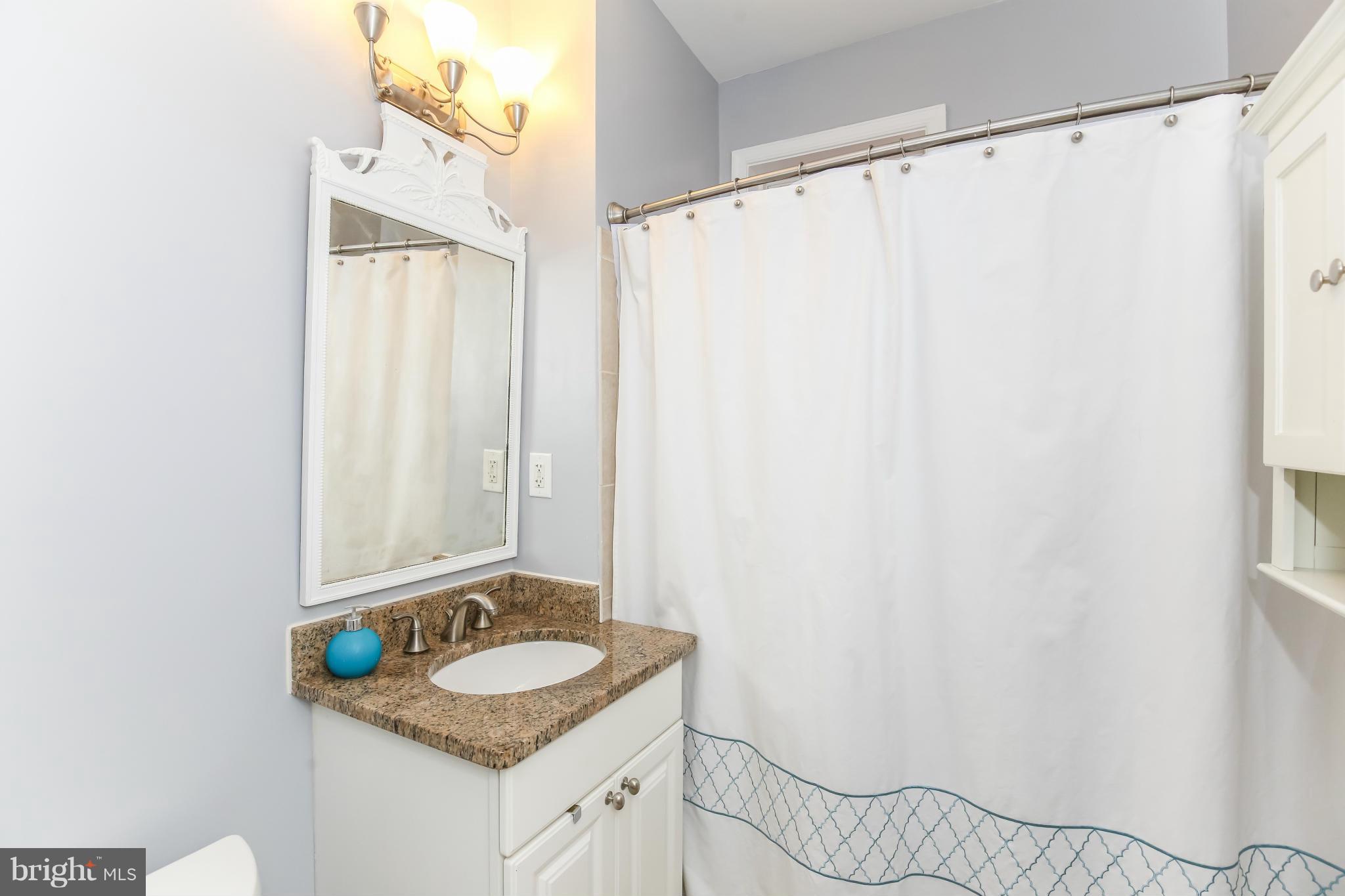 1438 Columbia Road Northwest, Unit 402 Washington, DC 20009 - Photo 12 of 12 a bathroom with a granite countertop sink and a mirror