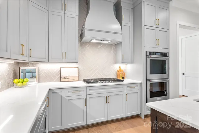 a kitchen with stainless steel appliances granite countertop a sink dishwasher stove and cabinets