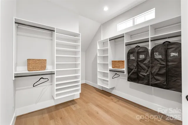 a view of walk in closet with clothes and shoes
