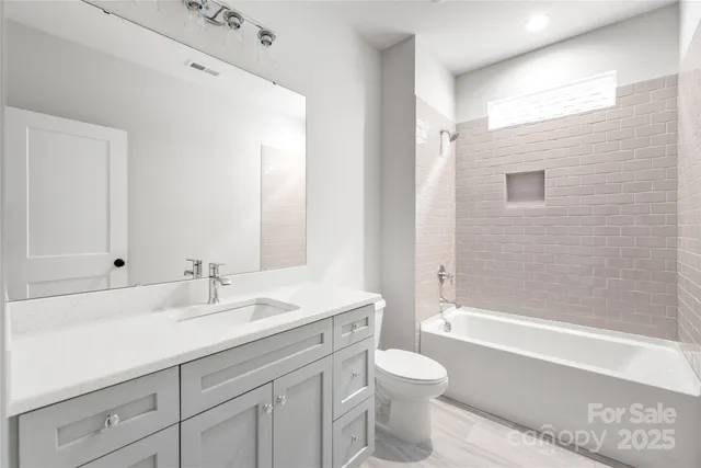 a bathroom with a granite countertop sink a toilet and a bathtub