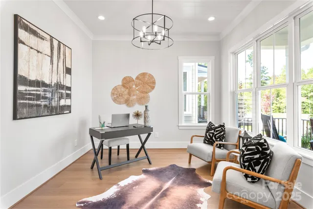 a view of a dining room with furniture a chandelier and a window