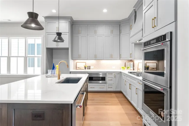 a kitchen with stainless steel appliances granite countertop a sink and a stove