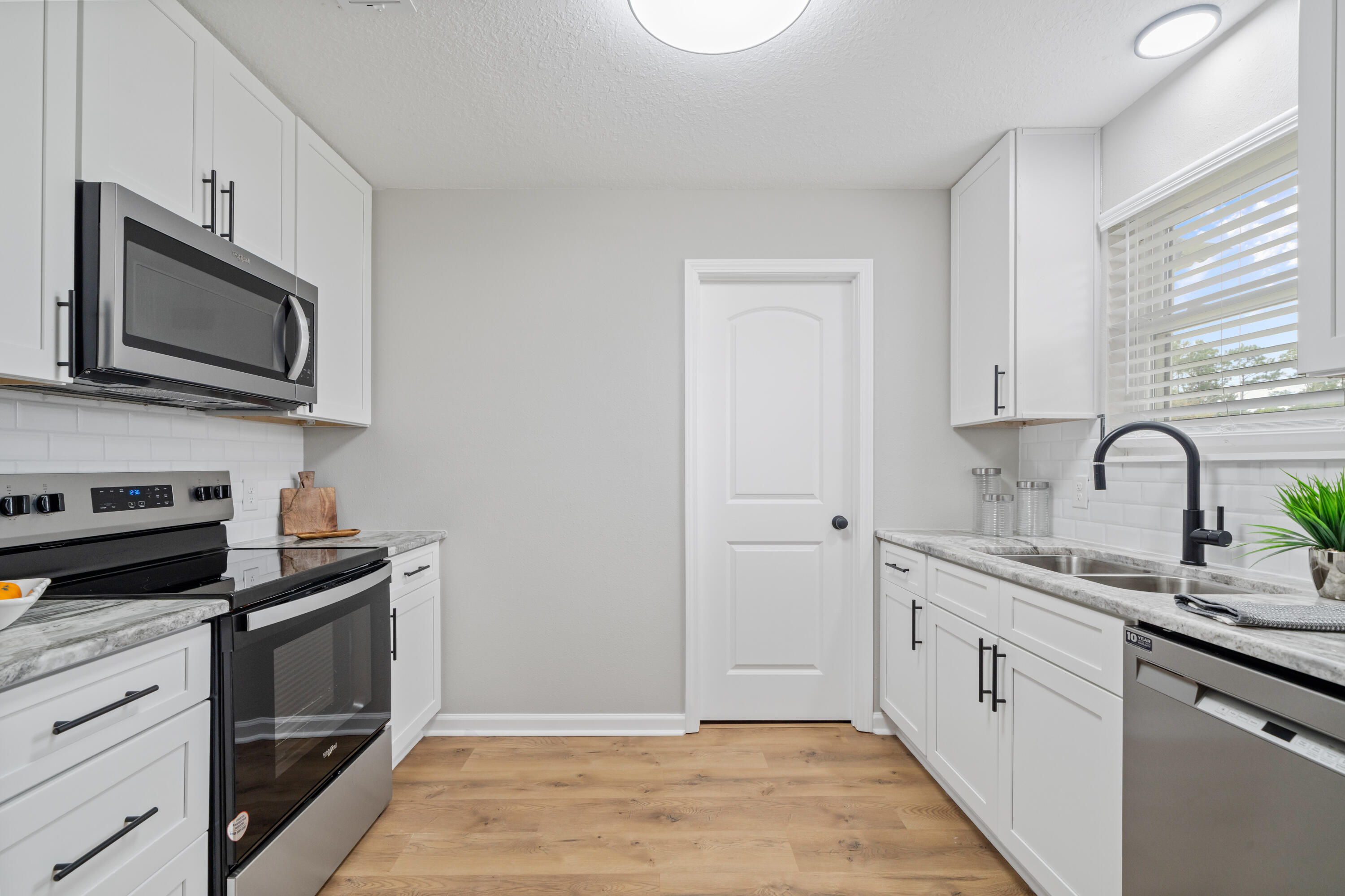 37 Beech Lane DeFuniak Springs, FL 32435 - Photo 3 of 26 a kitchen with stainless steel appliances granite countertop white cabinets a sink a stove and a microwave