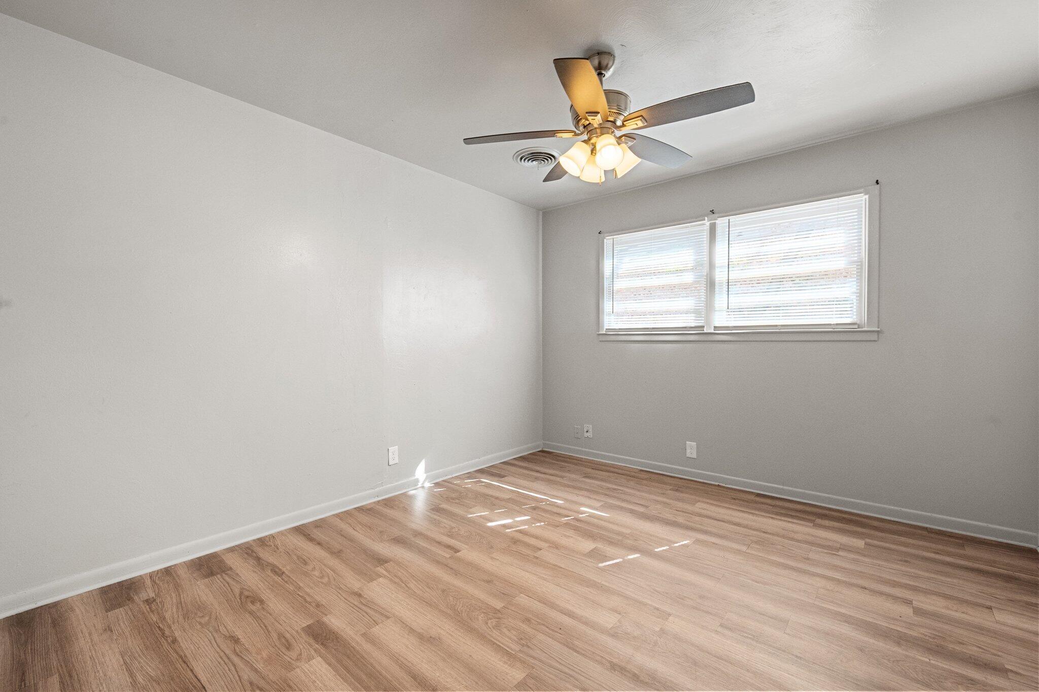 2319 53rd Street Lubbock, TX 79412 - Photo 12 of 20 an empty room with wooden floor fan and windows