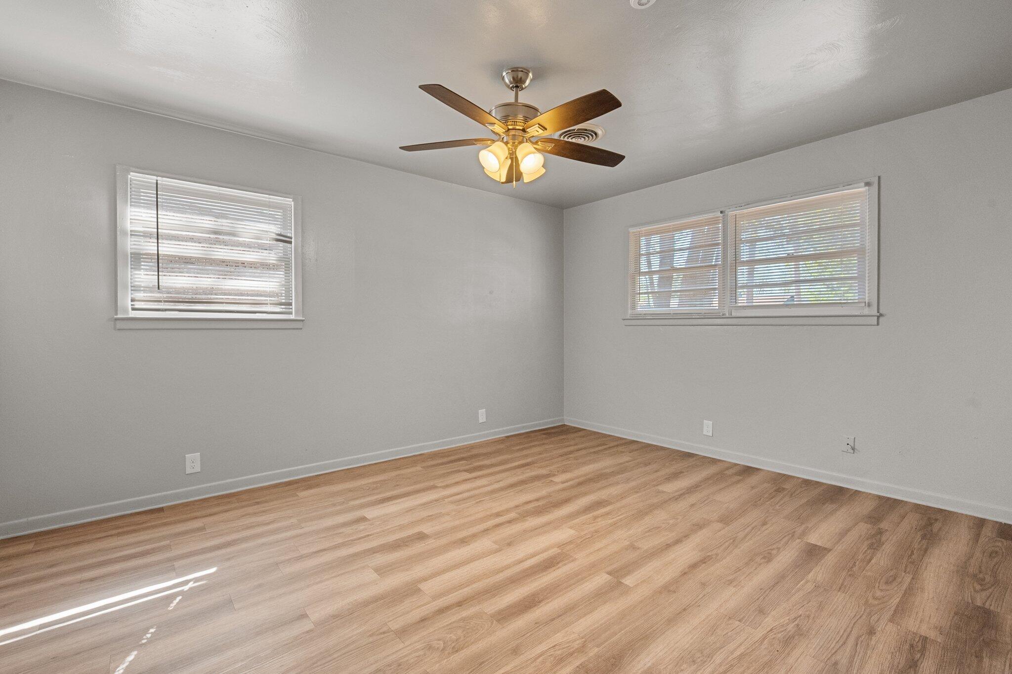 2319 53rd Street Lubbock, TX 79412 - Photo 13 of 20 a view of an empty room with window and wooden floor