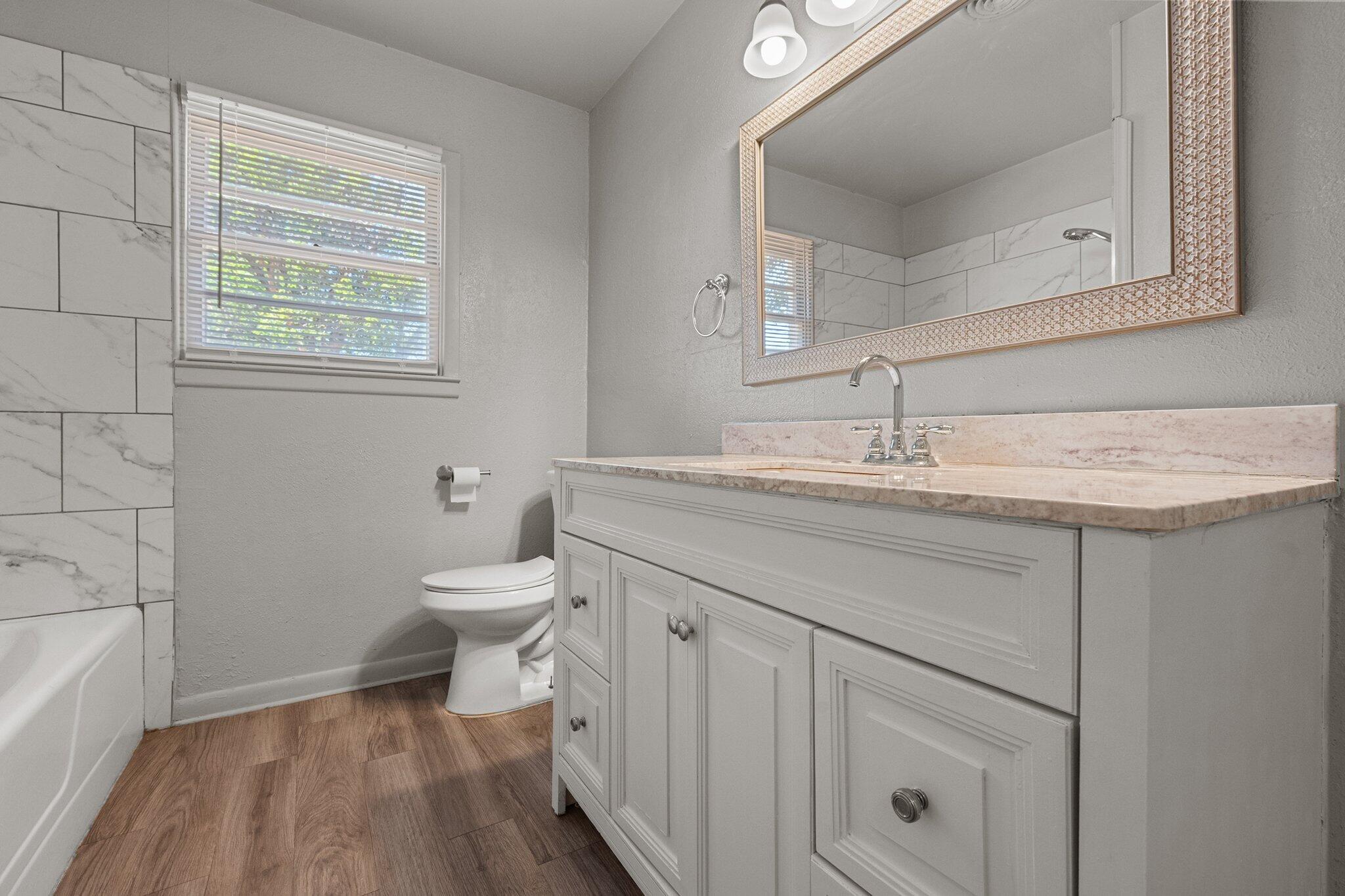 2319 53rd Street Lubbock, TX 79412 - Photo 14 of 20 a bathroom with a sink a toilet and a bathtub