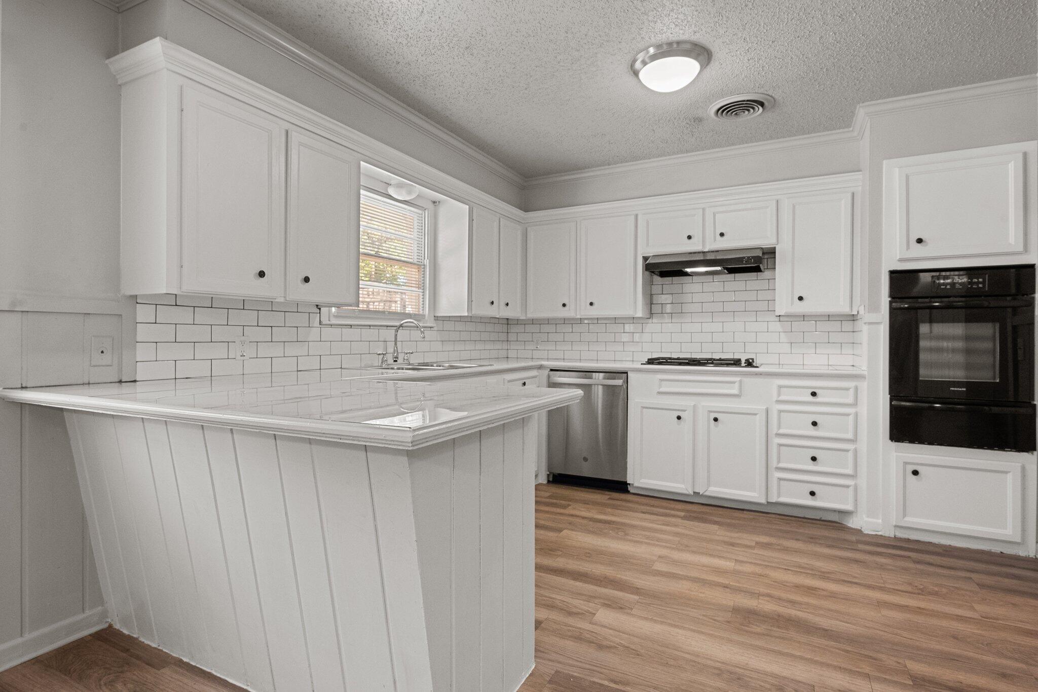 2319 53rd Street Lubbock, TX 79412 - Photo 6 of 20 a kitchen with stainless steel appliances sink a stove and white cabinets