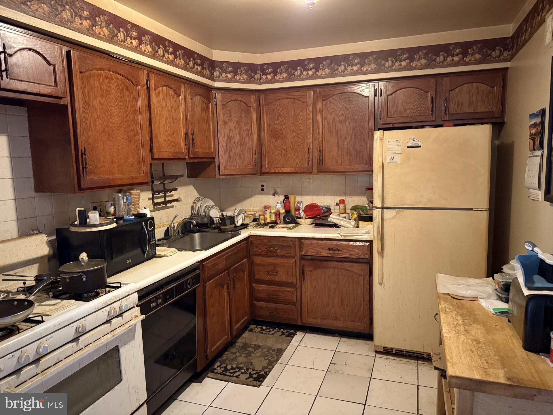 10218 Bustleton Avenue Philadelphia, PA 19116 - Photo 3 of 18 a kitchen with a refrigerator and a stove top oven