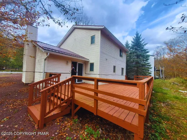 a view of house with a yard and deck