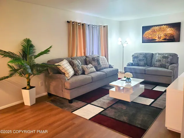 a living room with furniture potted plant and a window