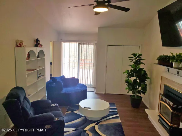 a living room with furniture a flat screen tv and a fireplace