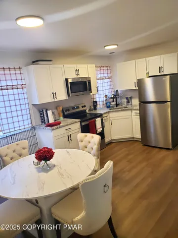 a kitchen with stainless steel appliances granite countertop a sink a stove a refrigerator a center island and cabinets