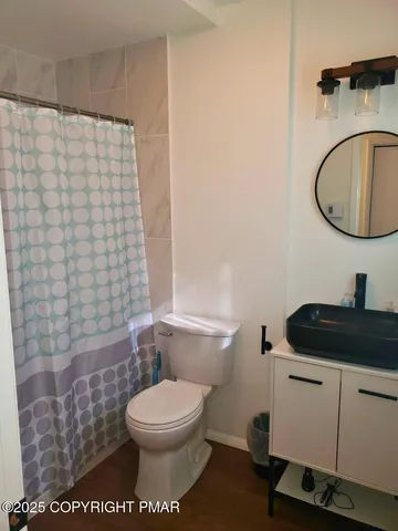 a bathroom with a granite countertop toilet a sink and a mirror
