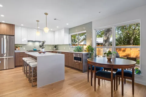 a kitchen with kitchen island granite countertop a sink and a refrigerator