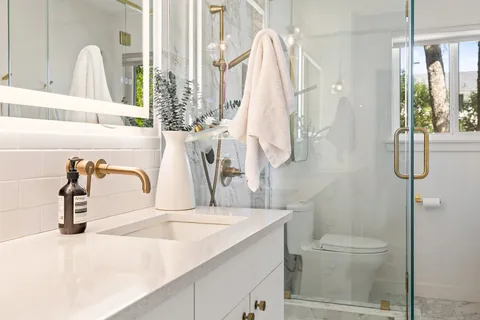 a bathroom with a sink and mirror with toilet