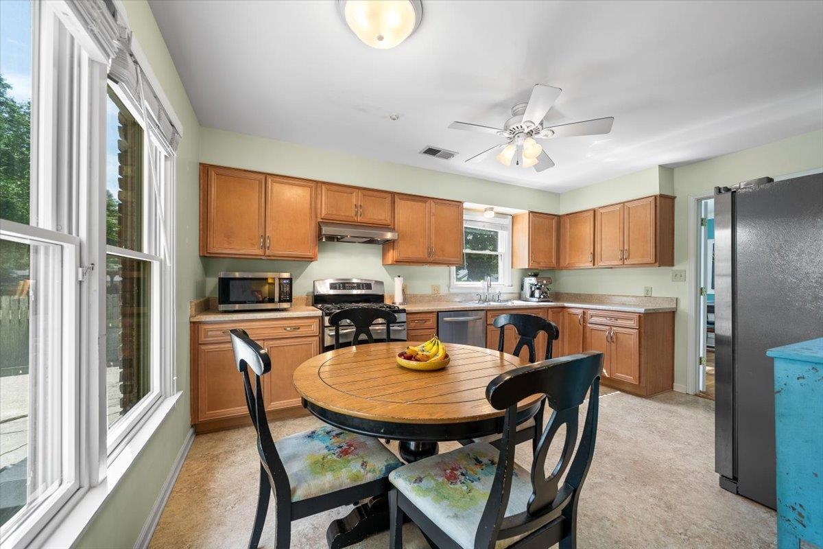 4847 Kaye Road Memphis, TN 38117 - Photo 14 of 40 a kitchen with stainless steel appliances granite countertop a stove a refrigerator a kitchen island a table and chairs