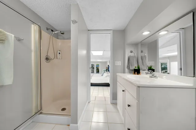 a spacious bathroom with a shower sink and mirror