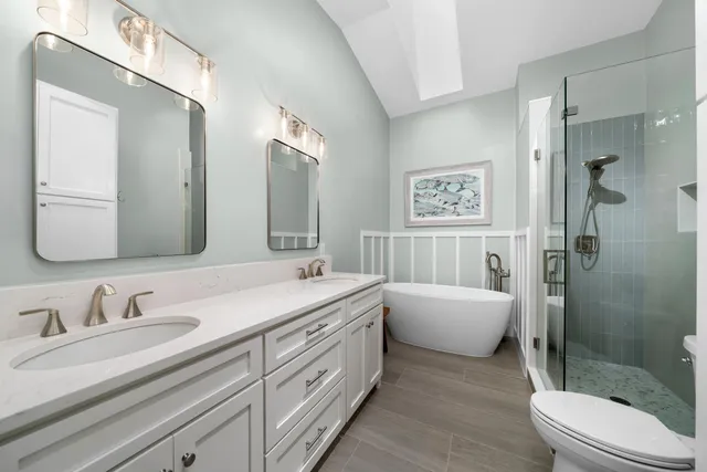 a spacious bathroom with a double vanity sink mirror double shower and a bathtub