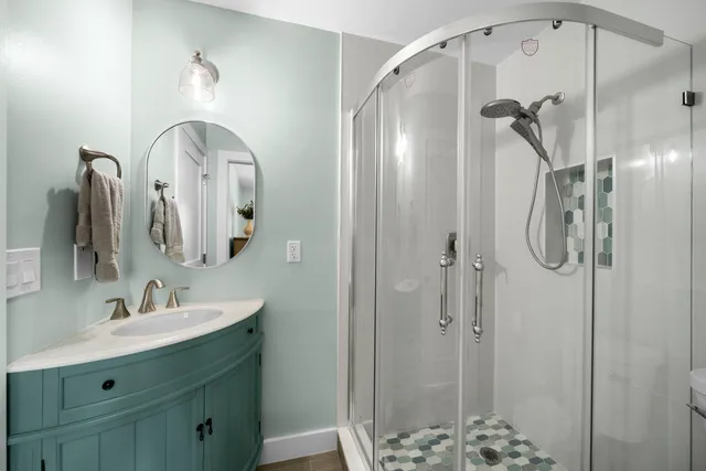 a bathroom with a double vanity sink mirror and shower