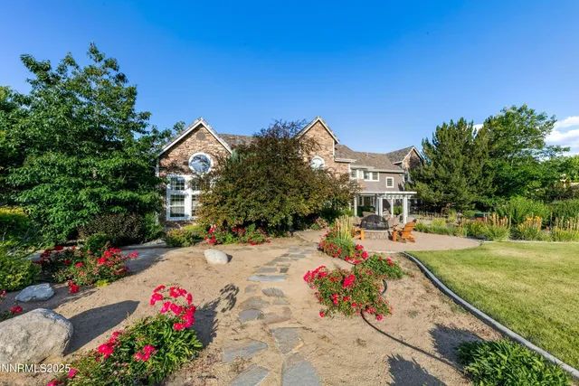 a front view of a house with garden and sitting area