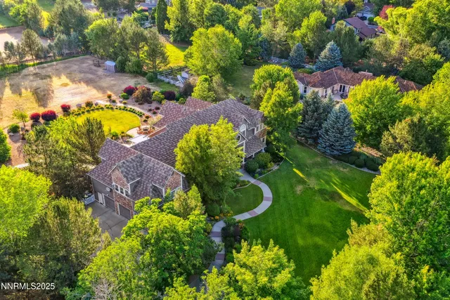 a view of a white house with a big yard and a large tree