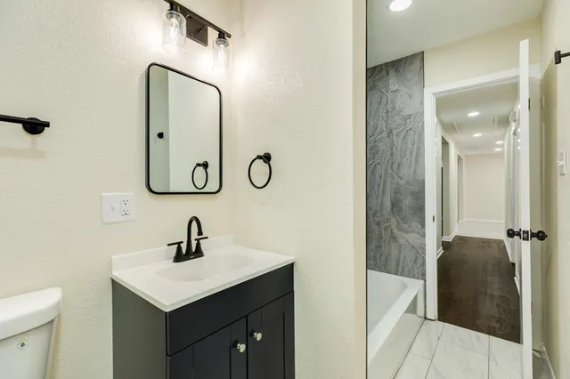 a bathroom with a toilet sink and mirror