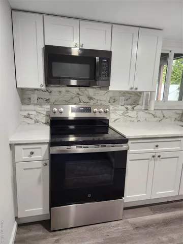 a stove top oven sitting inside of a kitchen