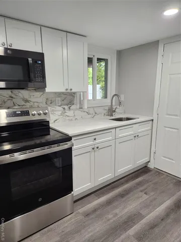 a kitchen with a sink stove and cabinets