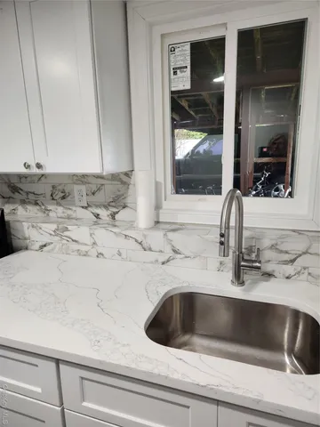 a view of a refrigerator in kitchen and an empty room